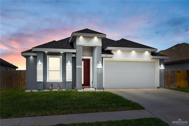 prairie-style home featuring a garage, fence, driveway, and stucco siding