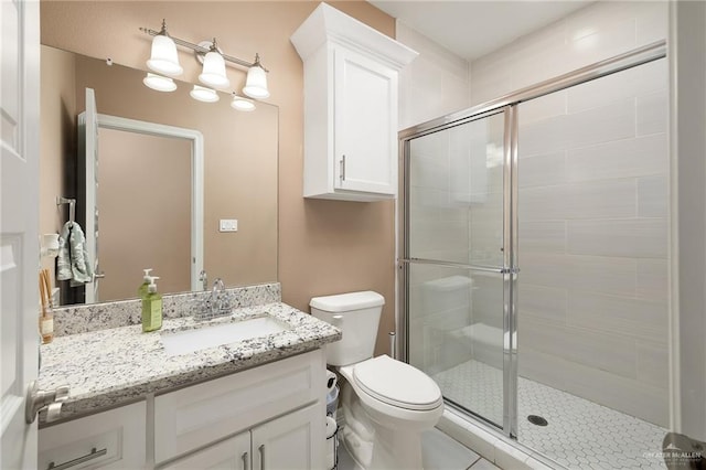 full bathroom featuring vanity, a stall shower, and toilet