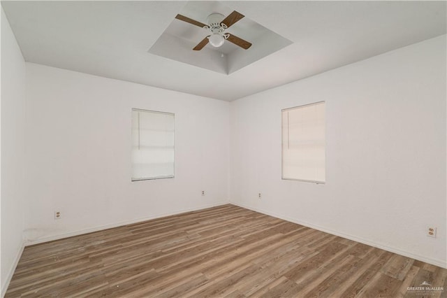 420 N Beto Garcia Dr, Weslaco, TX 78596 - empty room with wood finished floors, ceiling fan, a tray ceiling, and baseboards