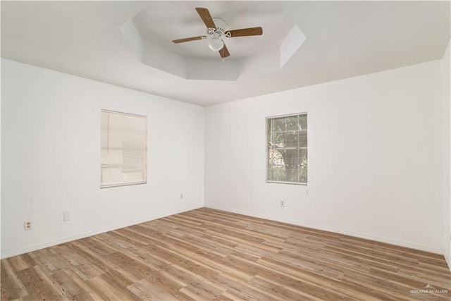420 N Beto Garcia Dr, Weslaco, TX 78596 - unfurnished room featuring light wood finished floors, a tray ceiling, a ceiling fan, and baseboards