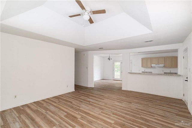 420 N Beto Garcia Dr, Weslaco, TX 78596 - unfurnished living room with light wood finished floors, a ceiling fan, and a tray ceiling