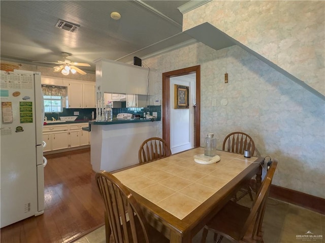 415 S Glasscock Blvd, Mission, TX 78573 - dining space with wallpapered walls, a ceiling fan, wood finished floors, and ornamental molding