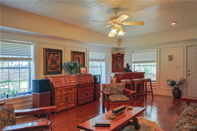 415 S Glasscock Blvd, Mission, TX 78573 - living area featuring ceiling fan, dark wood-style floors, a decorative wall, and ornamental molding