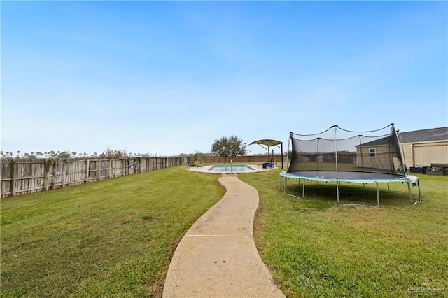 view of yard with a fenced in pool and a trampoline