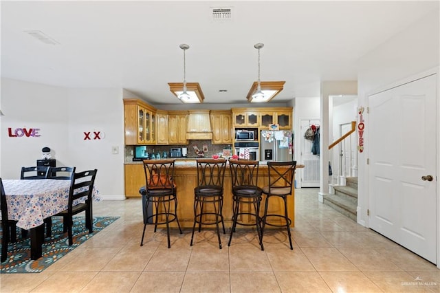 kitchen with premium range hood, light tile patterned floors, stainless steel appliances, decorative backsplash, and pendant lighting