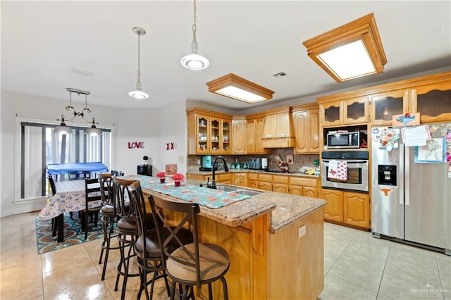 kitchen featuring light tile patterned floors, appliances with stainless steel finishes, backsplash, and sink