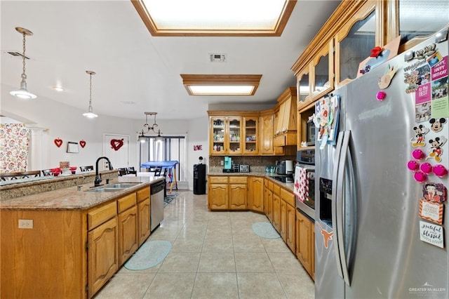 kitchen featuring appliances with stainless steel finishes, tasteful backsplash, light tile patterned flooring, pendant lighting, and sink