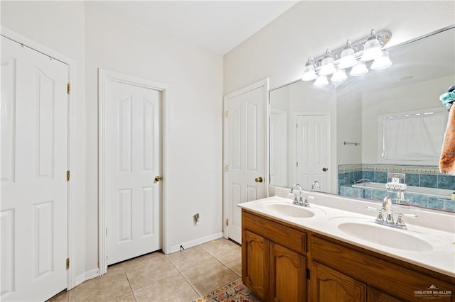 bathroom featuring tile patterned flooring, a tub to relax in, and vanity