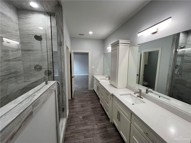 bathroom featuring vanity, hardwood / wood-style flooring, toilet, and an enclosed shower