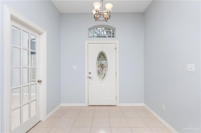 tiled entrance foyer featuring a notable chandelier