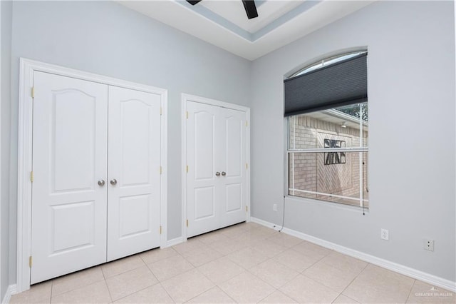 unfurnished bedroom featuring light tile patterned flooring and ceiling fan