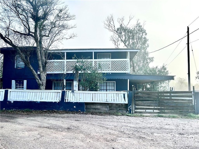 view of front of home featuring fence and a balcony