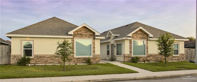 4012 Whitewing Ave, Edinburg, TX 78539 - craftsman inspired home with fence, a front yard, stone siding, stucco siding, and a shingled roof