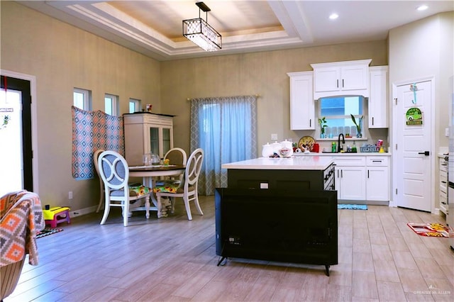 506 Oak Ridge St, Donna, TX 78537 - kitchen featuring a tray ceiling, white cabinetry, light countertops, and a kitchen island