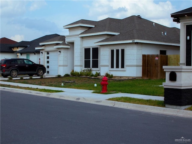 506 Oak Ridge St, Donna, TX 78537 - view of front of home featuring an attached garage, fence, a front lawn, and roof with shingles