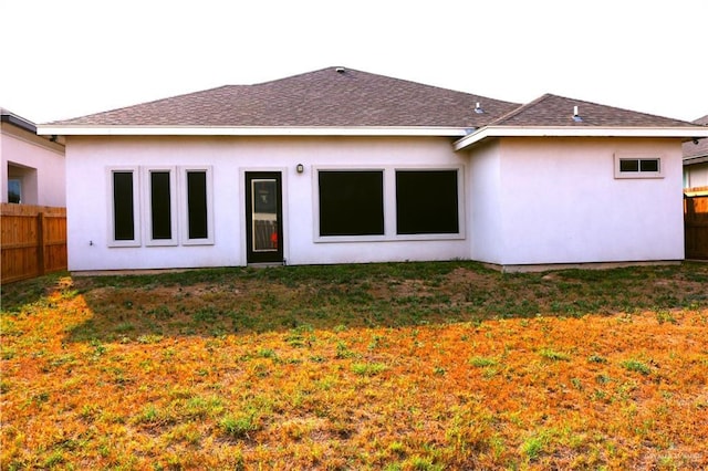 506 Oak Ridge St, Donna, TX 78537 - rear view of property with a lawn, fence, roof with shingles, and stucco siding