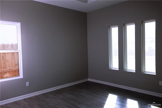 506 Oak Ridge St, Donna, TX 78537 - unfurnished room with dark wood-type flooring, baseboards, and a wealth of natural light