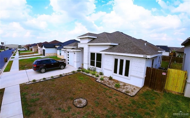 506 Oak Ridge St, Donna, TX 78537 - view of front of home with fence, concrete driveway, a front yard, a residential view, and a shingled roof