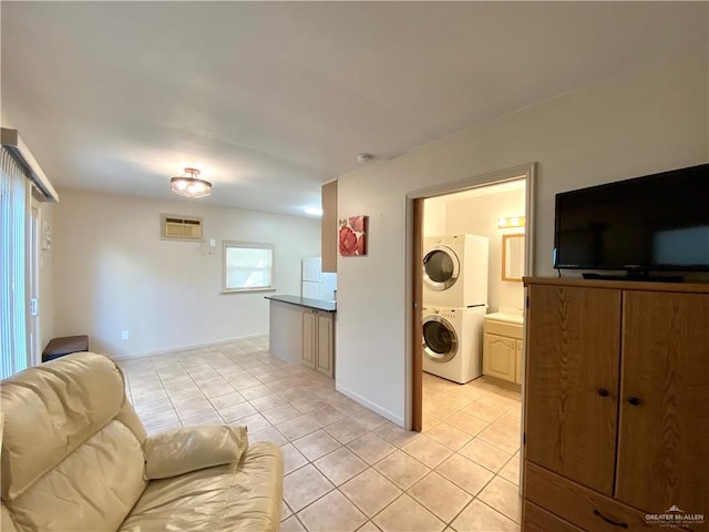 tiled living room with a wall unit AC and stacked washer / dryer