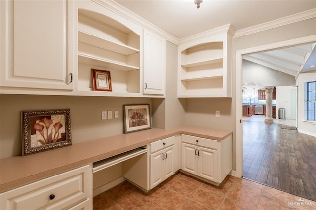 office area featuring baseboards, built in study area, lofted ceiling, ornamental molding, and ornate columns