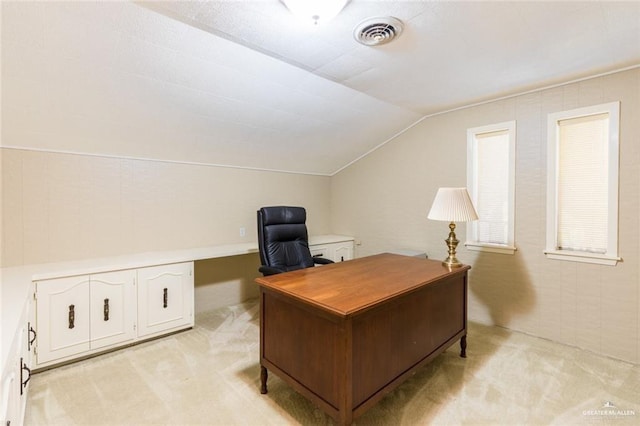 office area with vaulted ceiling, visible vents, and light colored carpet