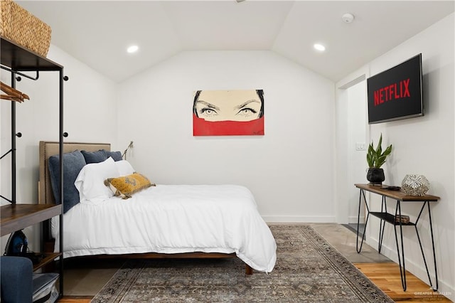 bedroom with wood-type flooring and lofted ceiling