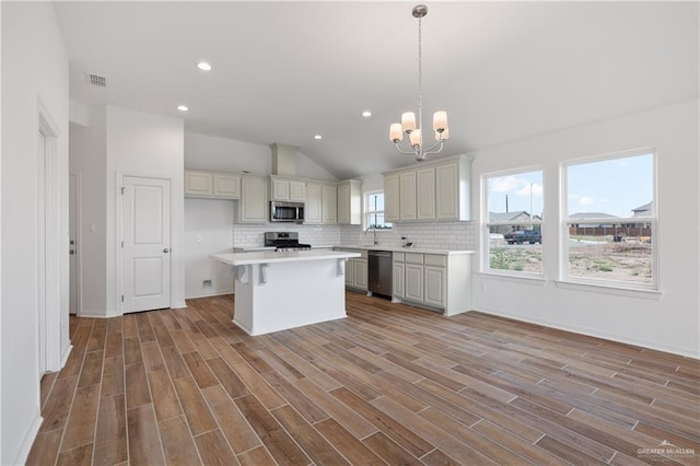 kitchen with an inviting chandelier, visible vents, vaulted ceiling, light countertops, and appliances with stainless steel finishes