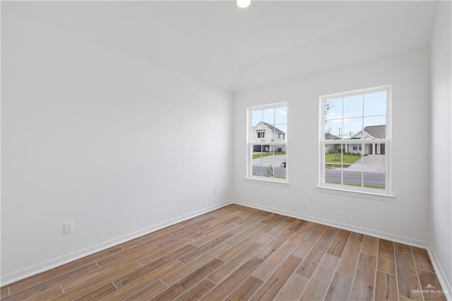 empty room with wood finished floors, baseboards, and recessed lighting
