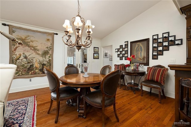 dining area featuring lofted ceiling, hardwood / wood-style floors, and a notable chandelier