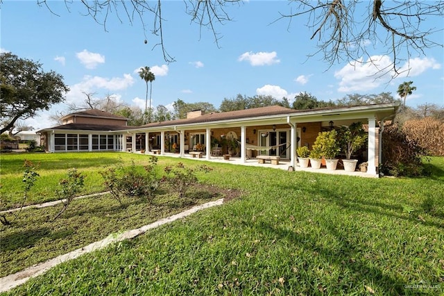 rear view of property featuring a patio and a lawn