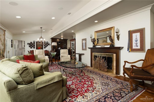 living room featuring ornamental molding, hardwood / wood-style floors, and a notable chandelier