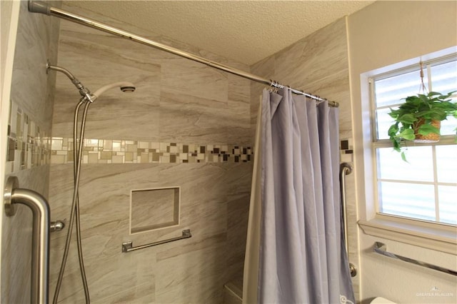 bathroom featuring a textured ceiling and walk in shower