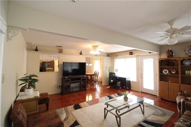 tiled living room featuring ceiling fan and a textured ceiling