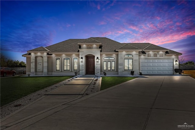 view of front of house featuring a garage and a lawn