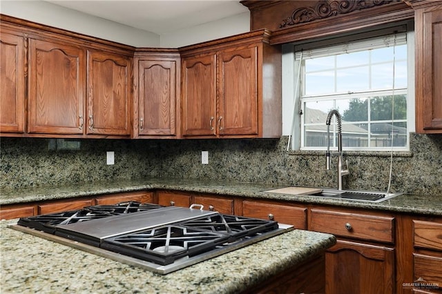 904 S Diplomat Dr, Pharr, TX 78577 - kitchen with stainless steel gas cooktop, backsplash, and brown cabinets