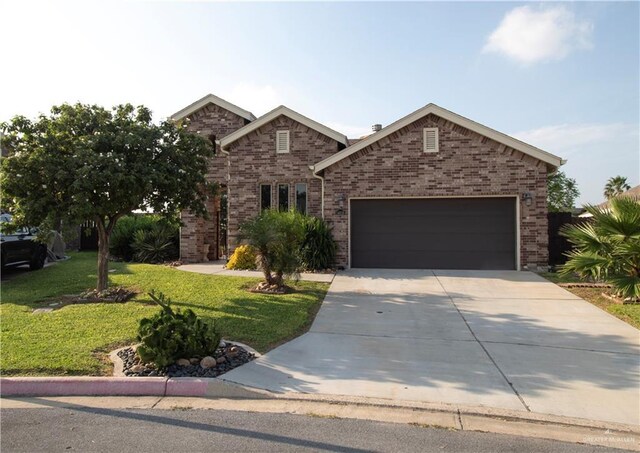 14616 Kurth Cv, Mcallen, TX 78504 - view of front of house featuring driveway, a front yard, an attached garage, and brick siding