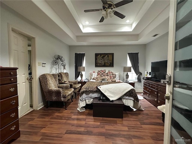 bedroom featuring a raised ceiling, ceiling fan, and dark hardwood / wood-style floors