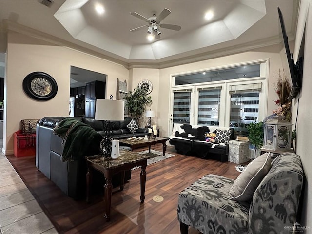 living room with ceiling fan, crown molding, dark hardwood / wood-style floors, and a tray ceiling