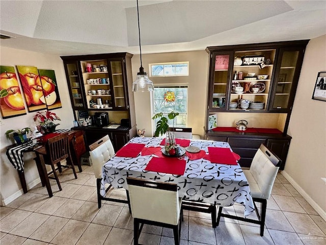 dining space featuring lofted ceiling and light tile patterned flooring