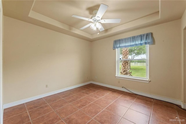 12612 E Clark Rd, La Feria, TX 78559 - unfurnished room featuring a tray ceiling, light tile patterned floors, and baseboards