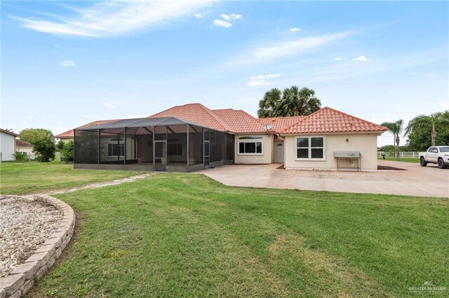12612 E Clark Rd, La Feria, TX 78559 - back of house with a tile roof, a yard, a patio area, stucco siding, and glass enclosure