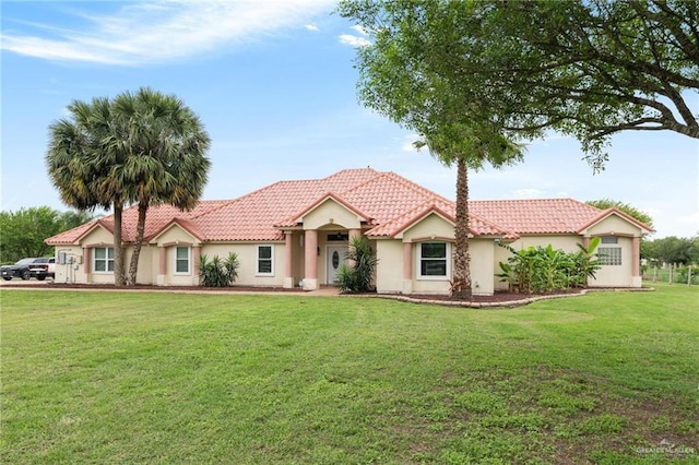 12612 E Clark Rd, La Feria, TX 78559 - view of front of house featuring a front yard, a tiled roof, and stucco siding