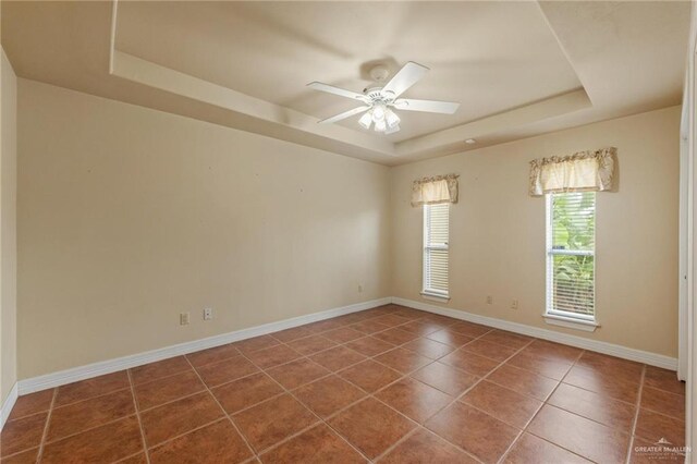 12612 E Clark Rd, La Feria, TX 78559 - tiled spare room with a raised ceiling, a ceiling fan, and baseboards