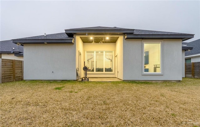 rear view of property featuring a lawn