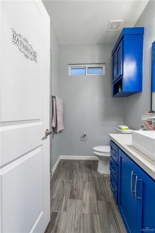 bathroom with hardwood / wood-style flooring, vanity, and toilet