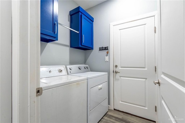 laundry area featuring cabinets, independent washer and dryer, and light hardwood / wood-style floors