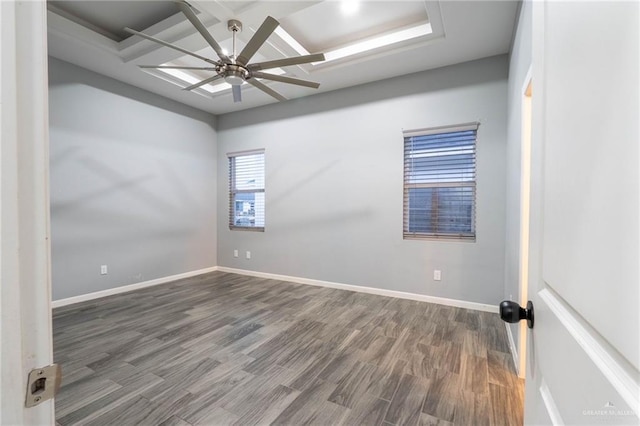 spare room with dark wood-type flooring, ceiling fan, and coffered ceiling