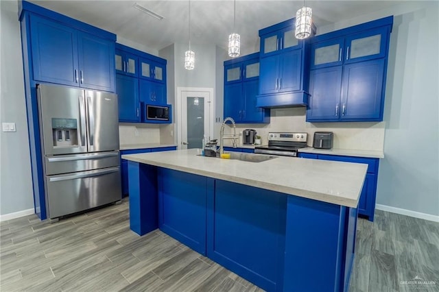 kitchen with blue cabinetry, sink, hanging light fixtures, a center island with sink, and appliances with stainless steel finishes