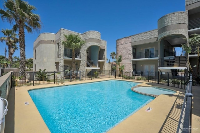 view of swimming pool with a hot tub