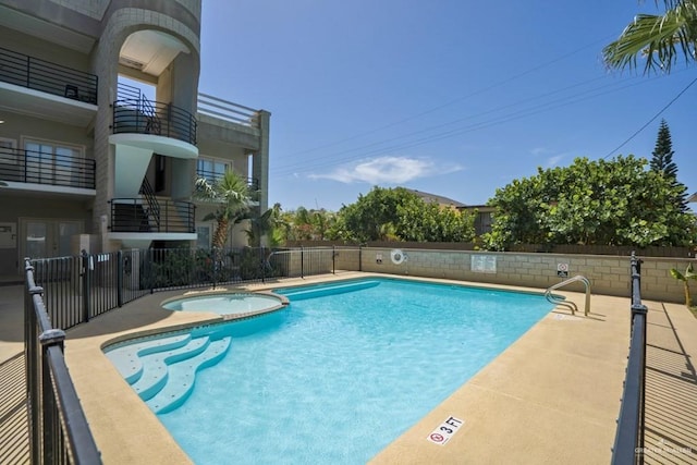 view of swimming pool featuring a community hot tub